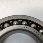 SRO 1214 double row self-aligning ball bearing, 70mm ID x 125mm OD x 24mm Width, with stamped steel cage. Accommodates angular misalignment, 5300 rpm limit, ideal for simple mounting in industrial machines globally.