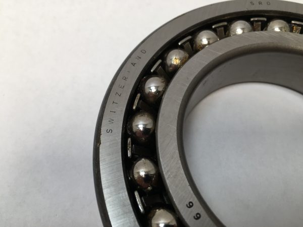 SRO 1214 double row self-aligning ball bearing, 70mm ID x 125mm OD x 24mm Width, with stamped steel cage. Accommodates angular misalignment, 5300 rpm limit, ideal for simple mounting in industrial machines globally.