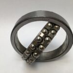 SRO 1214 double row self-aligning ball bearing, 70mm ID x 125mm OD x 24mm Width, with stamped steel cage. Accommodates angular misalignment, 5300 rpm limit, ideal for simple mounting in industrial machines globally.
