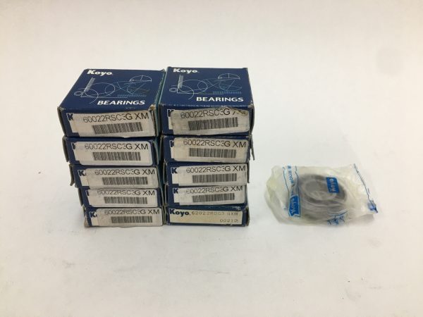 Ten boxed Koyo 60022RSC3 deep groove ball bearings stacked beside one bearing in a plastic bag