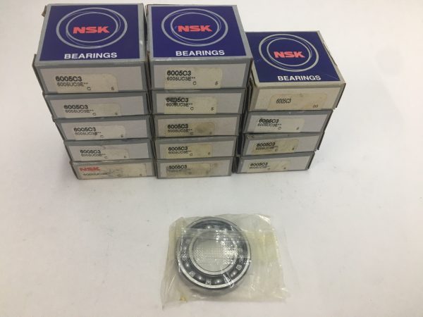 Stacked NSK 6005C3 bearing boxes beside one unwrapped deep groove ball bearing