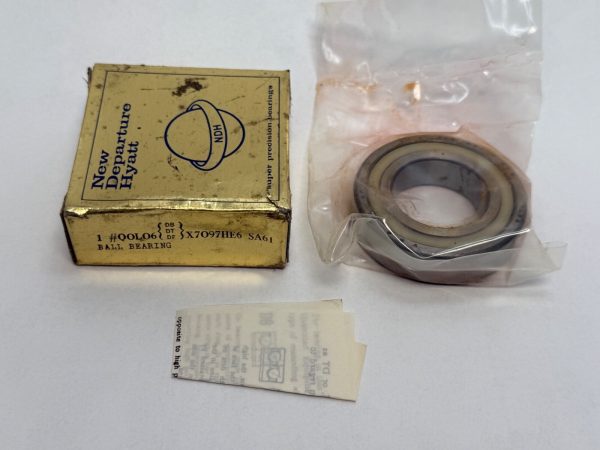 NDH Q0L06DT angular contact ball bearing in plastic packaging beside its New Departure Hyatt box