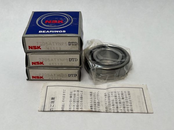 Stacked NSK 7205ATYNP5DTD boxes beside an unwrapped angular contact ball bearing and Japanese instruction sheet