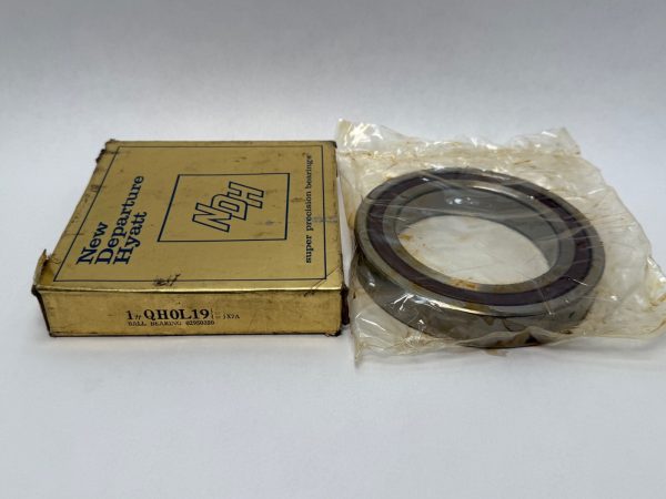 NDH Q0L19DTX7A angular contact ball bearing in plastic wrap beside its New Departure Hyatt box