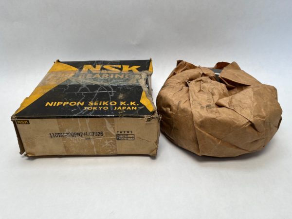NSK 110TAC20DPN7+LC7U26 thrust bearing box beside bearing wrapped in brown paper