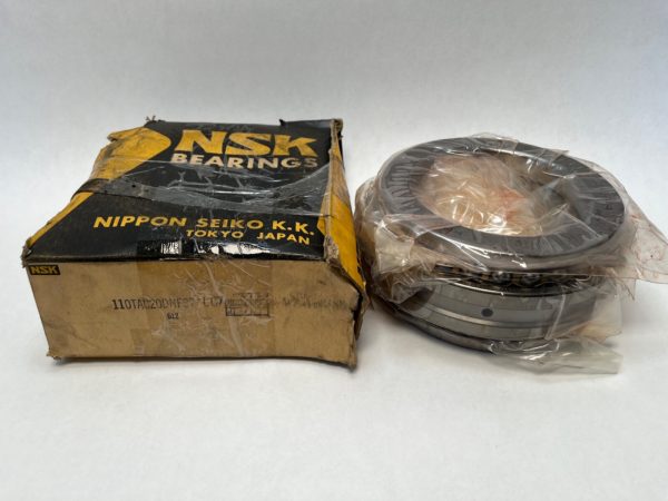 NSK 110TAC20DNES7+LC7 angular contact thrust ball bearing, shrink-wrapped, beside its original NSK box