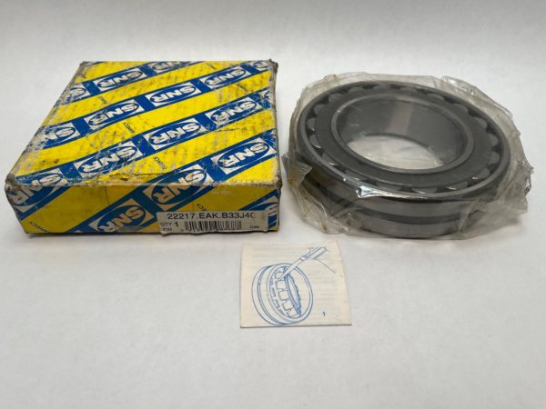 SNR 22217EAKB33J40 spherical roller bearing, shrink-wrapped, beside its yellow SNR box and instruction sheet