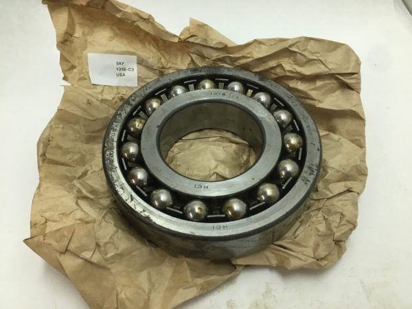 SKF 1318-C3 self-aligning ball bearing with visible balls and races, resting on brown paper packaging