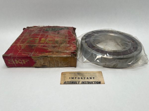 SKF 7220CTCC78G2 angular contact ball bearing in plastic wrap beside its worn red SKF box and assembly instruction slip