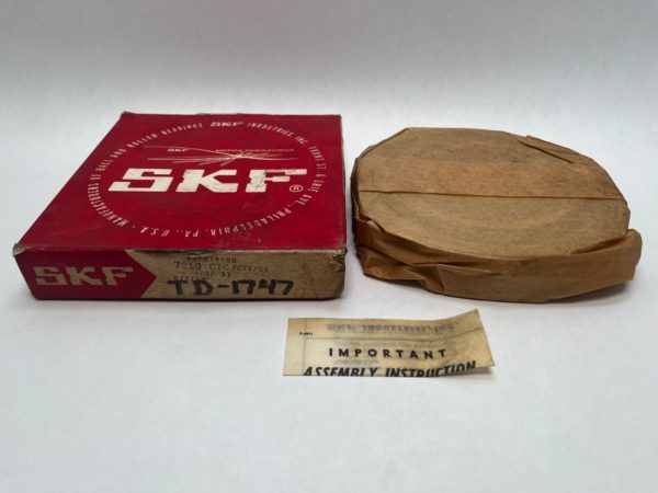 SKF 7219CTCC78G4 angular contact ball bearing in original red box, next to its wrapped paper packaging