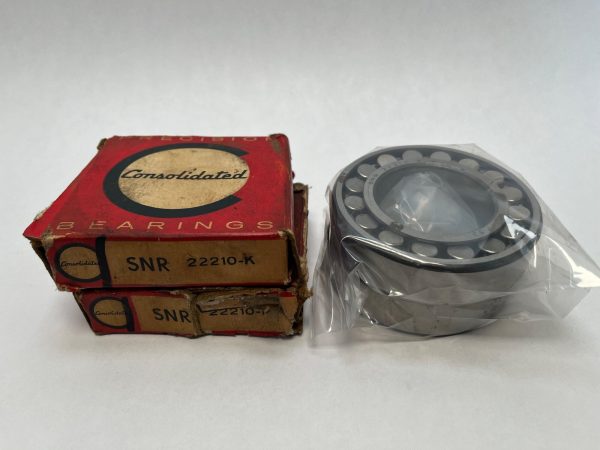 SNR 22210-K spherical roller bearing in plastic wrap beside two stacked Consolidated Bearings boxes