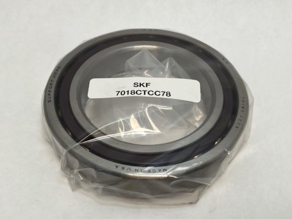 SKF 7018CTCC78 angular contact ball bearing, open, wrapped in plastic with label visible