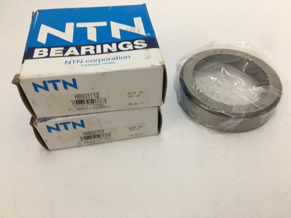 NTN HM803112 tapered roller bearing cup, plastic-wrapped, beside two NTN bearing boxes