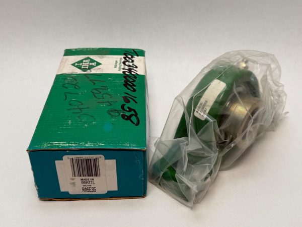 INA RASE35 pillow block bearing unit, green cast iron housing, in plastic wrap beside its labeled box