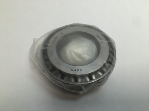 Koyo tapered roller bearing cone, 1-5/8 in. bore, wrapped in plastic on a plain background