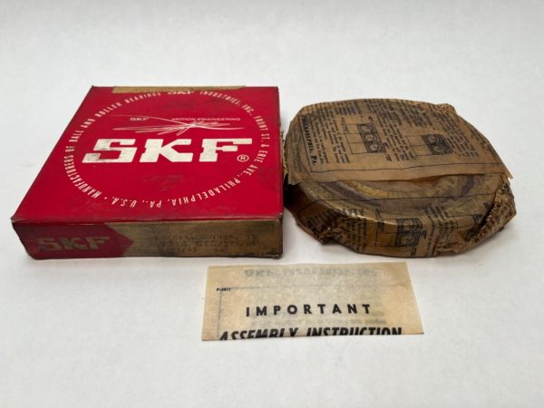 SKF 7214CTCC78G1 angular contact ball bearing, wrapped in paper, beside its red SKF box and instruction slip