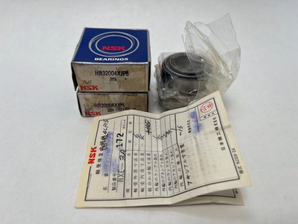 NSK HR32004XJP5 tapered roller bearing in plastic wrap beside two NSK boxes and an inspection slip