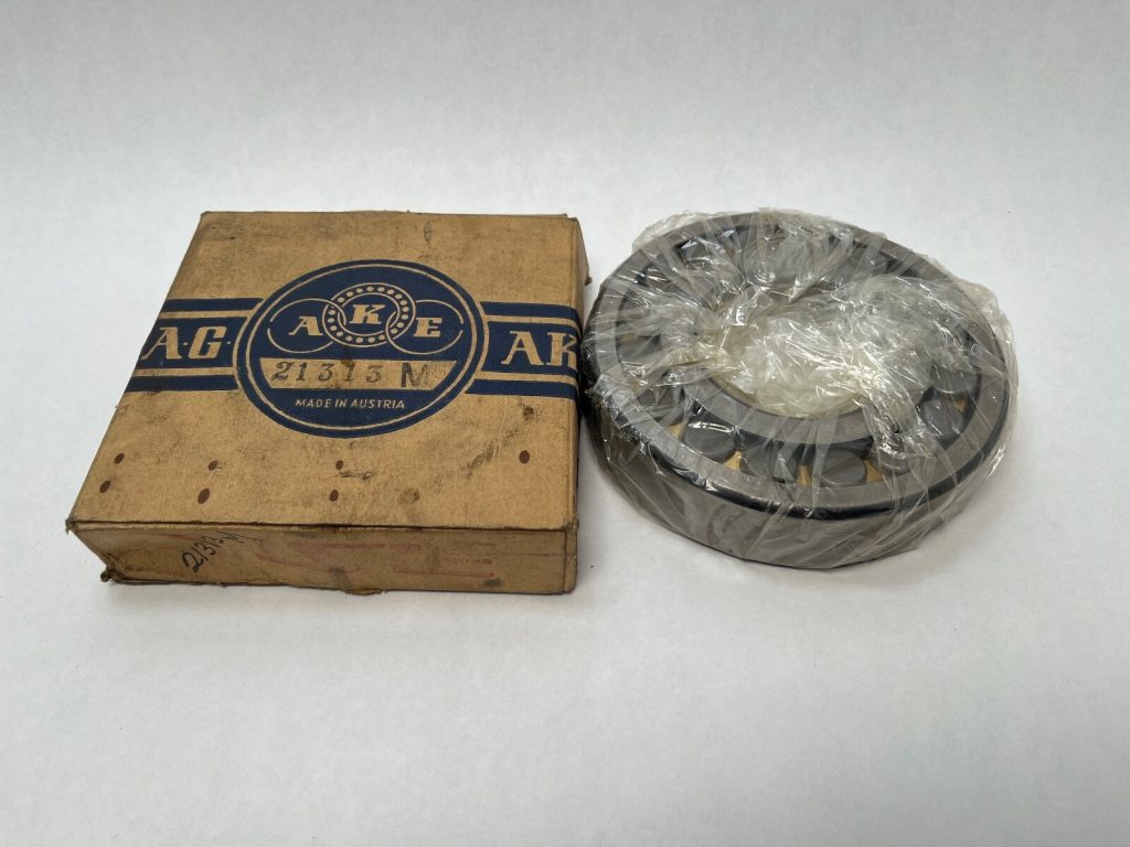 AKE 21313M spherical roller bearing, shrink-wrapped, next to its original AKE cardboard box