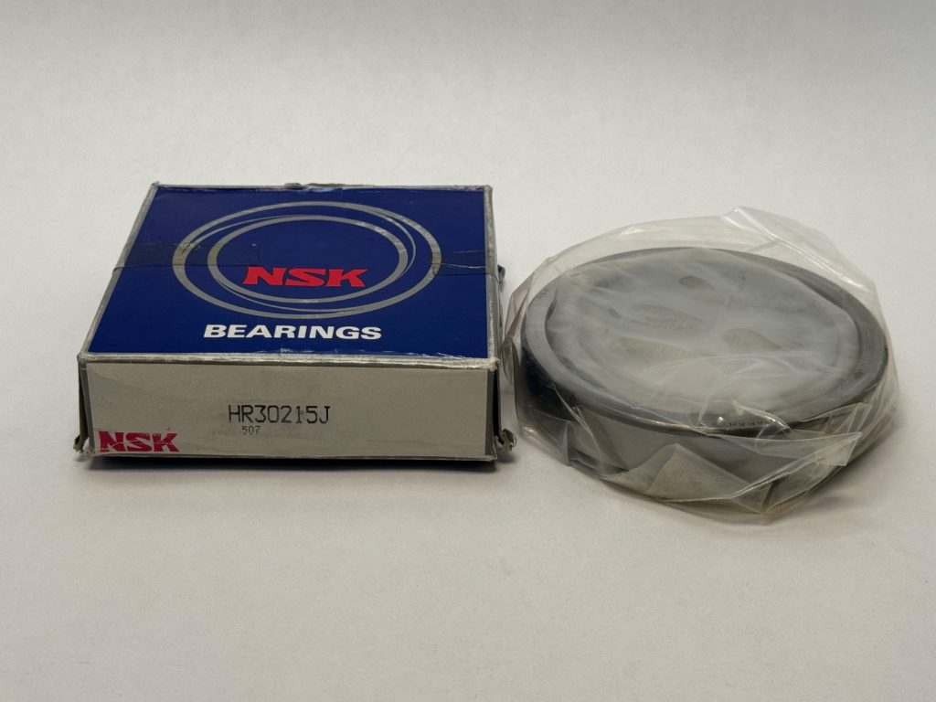 NSK tapered roller bearing cone and cup next to its NSK branded box labeled HR30215J