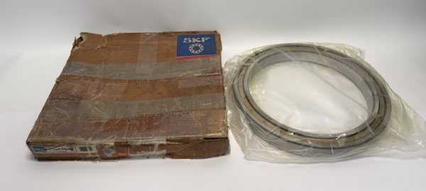 SKF open thin-section deep groove ball bearing in plastic wrap beside its worn cardboard box