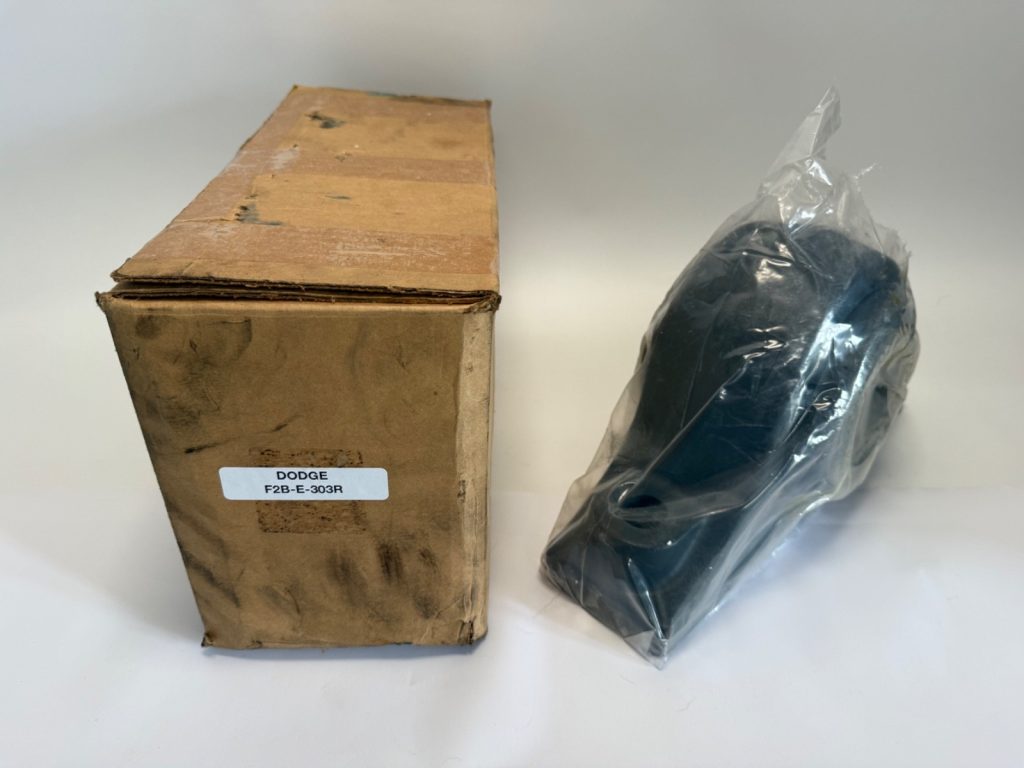 Dodge F4B-E-303R four-bolt flange bearing in plastic wrap next to its original labeled cardboard box