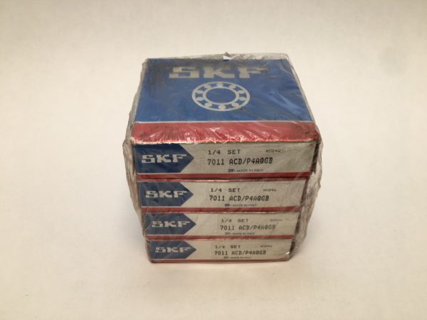 Stack of four shrink-wrapped SKF 7011 ACD/P4AQGB bearing boxes labeled 1/4 Set, Made in Italy
