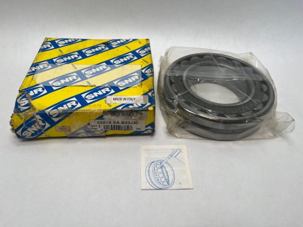 SNR 22218EAB33J30 double-row spherical roller bearing, shrink-wrapped, beside its yellow SNR box