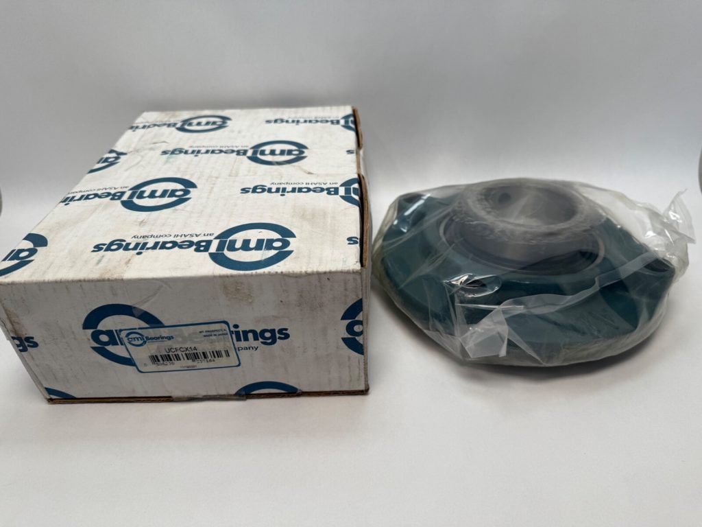 AMI piloted flange cartridge ball bearing unit in plastic wrap next to its AMI Bearings box