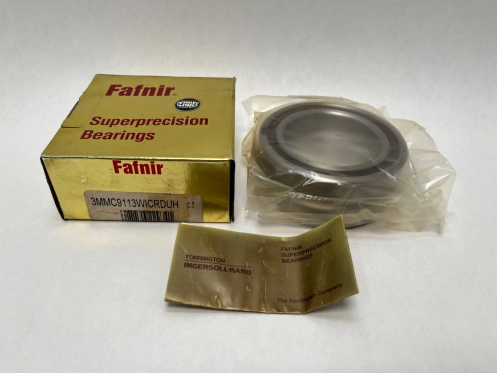 Fafnir 3MMC9113WICRDUH super-precision angular contact ball bearing, shrink-wrapped, beside its gold Fafnir box