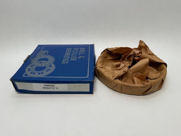 Timken M224710-3 tapered roller bearing cup next to its blue Timken box, wrapped in brown paper