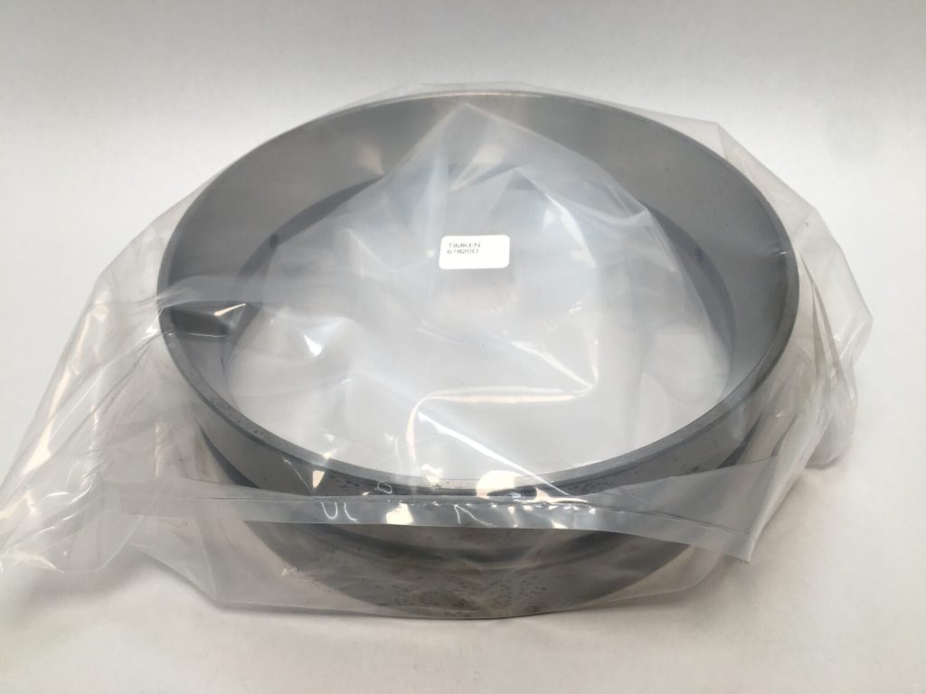 Timken 67820D double tapered roller bearing cup wrapped in plastic on a flat surface
