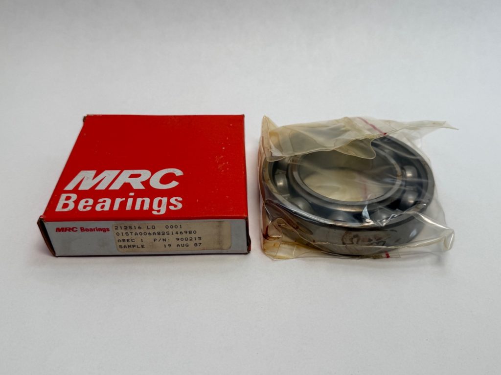 MRC 212S open deep groove ball bearing in plastic wrap next to its red MRC Bearings box