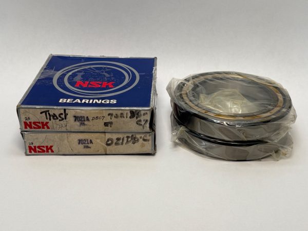 Two NSK 7021A angular contact ball bearings, shrink-wrapped, next to their original NSK boxes