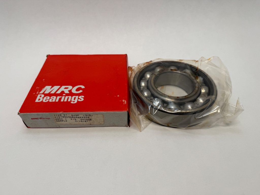 MRC 312M ball bearing in plastic wrap next to its red MRC Bearings box