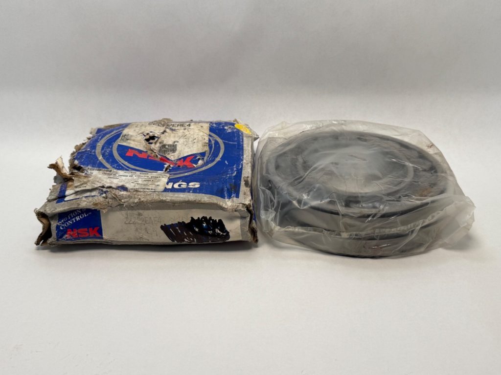 Fafnir 22228W33 spherical roller bearing next to its worn NSK packaging box, still wrapped in plastic